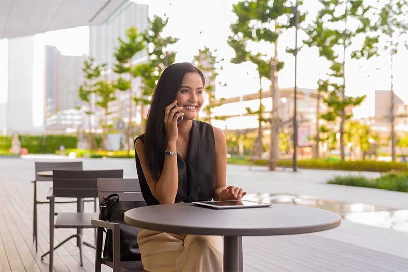 Person enjoying a coffee while using a smartphone at a café, illustrating the relaxed lifestyle and social spaces at Park Eight Place