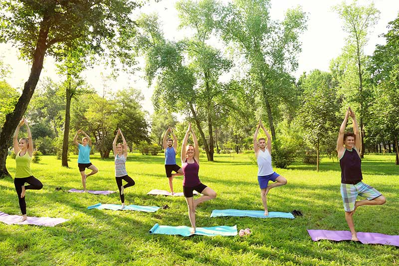 People practicing outdoor yoga, highlighting wellness and fitness activities at Park Eight Place in West Houston